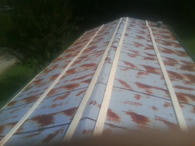 Rusted metal roof panels with new wood purlins before replacement — Storm Damage Roof Repair in Coffeyville by Roofing Brothers